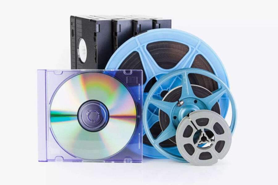 Verschillende soorten filmpjes en foto-opslagmedia zoals vhs-banden, dvd in hoesje en filmrollen in blauwe spoelen samen