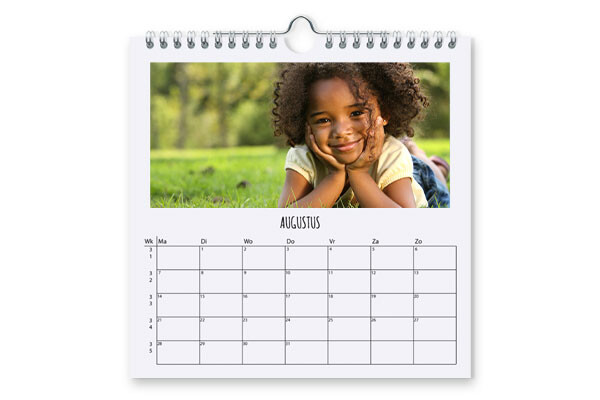 Kalender voor augustus met een glimlachend kind liggend op het gras in de natuur